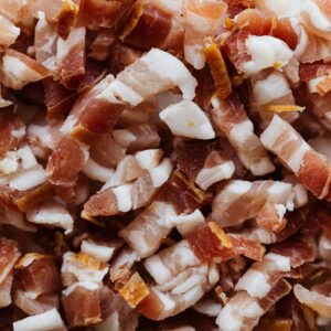 Closeup top view heap of delicious scrumptious pork bellies bacon cut into small slices before cooking process